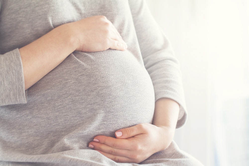 pregnant woman touching her belly Design for Recovery