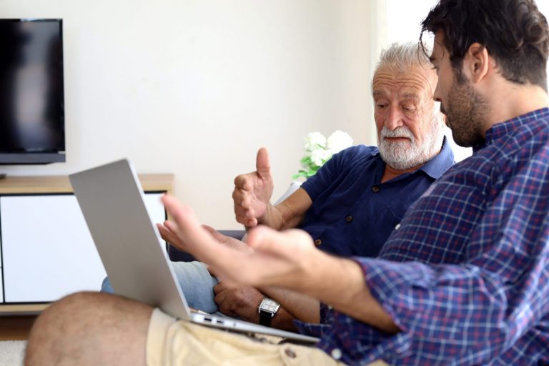 father and son looking at a laptop