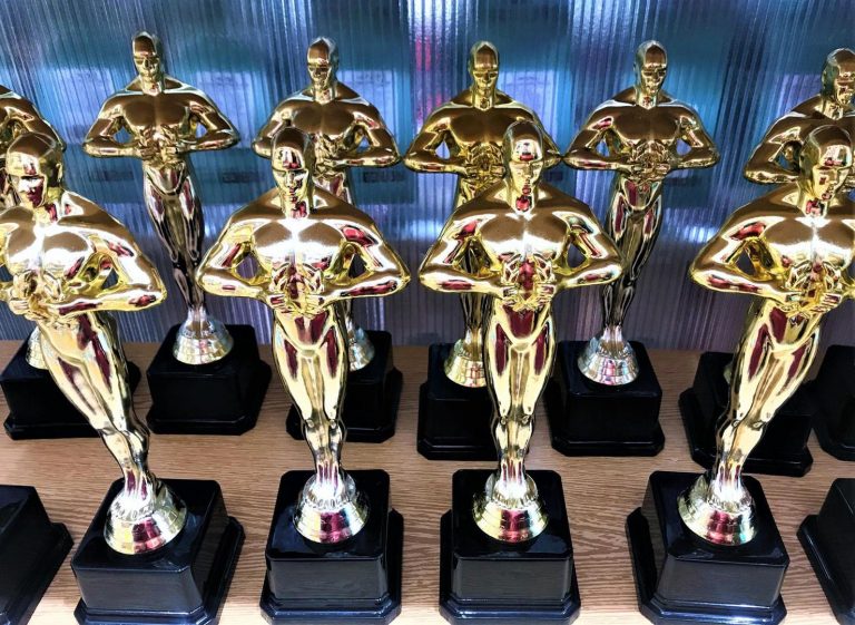 Many souvenir fake statuettes of the Oscar cinematic prize in the store on the shelf