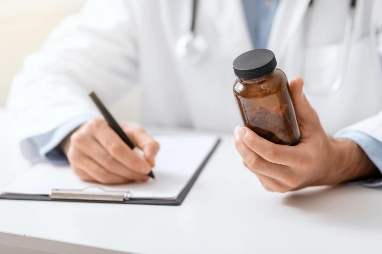Medical doctor writing prescription for patient about pills