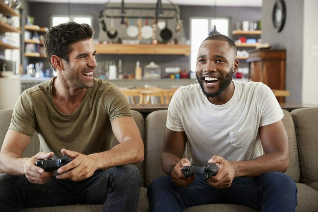 Two men playing video games while on a sober living facility - Design for Recovery
